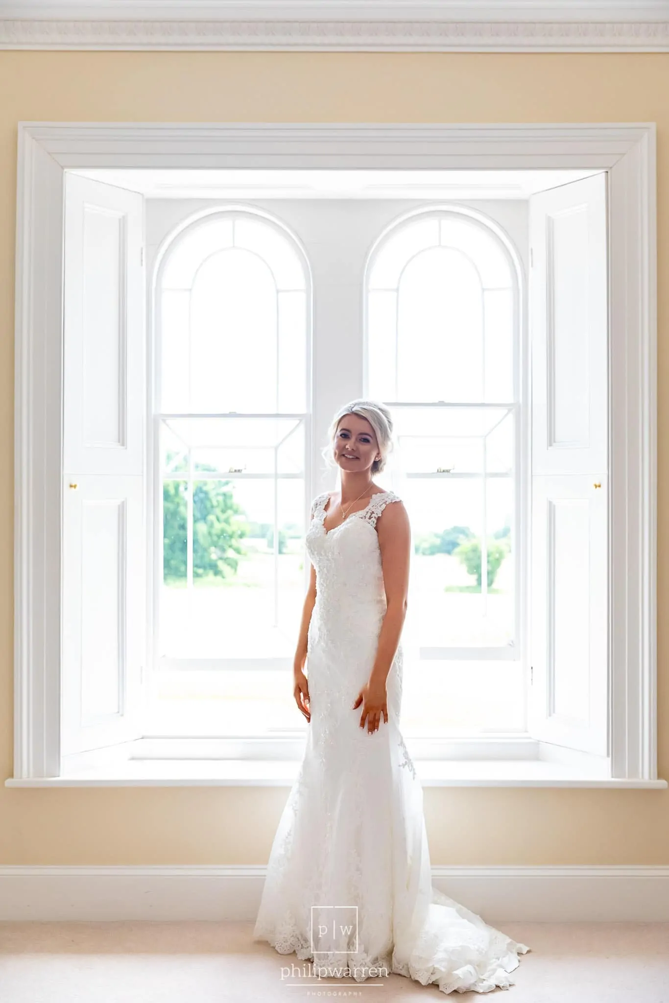 bright and light bridal protrait in the window of one of the bedrooms just before the wedding ceremony